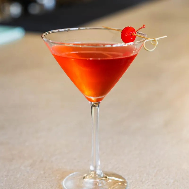 A bright cocktail garnished with a cherry at Thorpe’s 903
